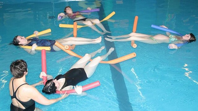Een zwemlerares met 4 zwangere vrouwen die drijven in het water