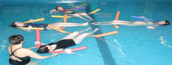 Een zwemlerares met 4 zwangere vrouwen die drijven in het water